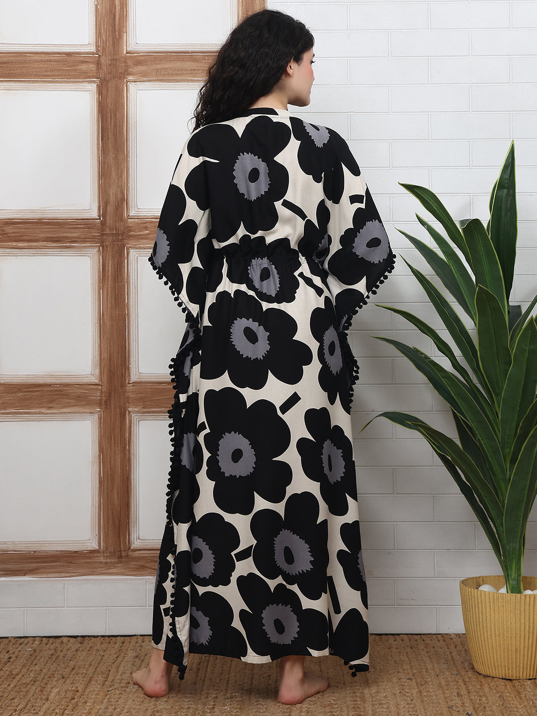 Back view of model in black floral Kaftan Dress